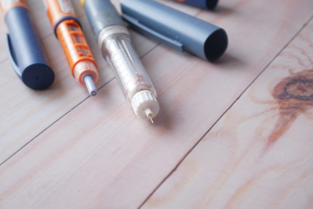 Insulin pens on wooden background,