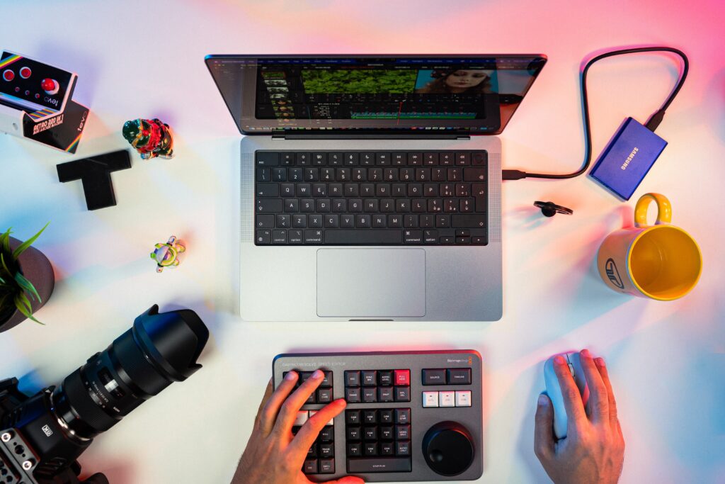 A person typing on a keyboard next to a laptop photo