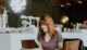 Woman sitting on brown wooden chair while using silver laptop