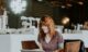 Woman sitting on brown wooden chair while using silver laptop